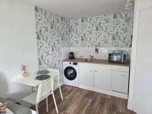 a small kitchen with a table and a microwave at Côté Jardin in Bolbec