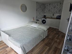 a small bedroom with a bed and a kitchen at Côté Jardin in Bolbec