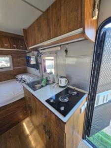 an rv kitchen with a sink and a bed at רויאל וואן in Tiberias