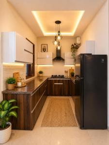 a kitchen with a black refrigerator and white cabinets at Amantra in Sohāna