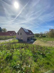 a large brick building with the sun in the sky at Villa Cdv in Ellezelles