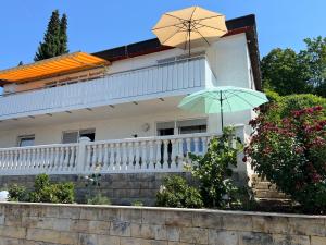 a white house with a balcony with an umbrella at Aida in Überlingen