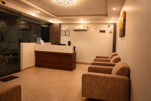 a waiting room with chairs and a reception desk at Guest House Suites in Bangalore +18 photos