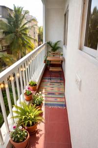 a balcony with a table and potted plants on it at Guest House Suites in Bangalore