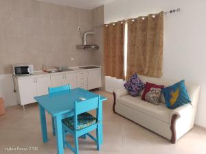 a living room with a blue table and a couch at Fort Apartments in Vila do Porto