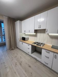 a kitchen with white cabinets and a counter top at ЖК Парус, 9-1 in Chornomorsk