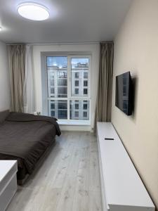 a bedroom with a bed and a large window at ЖК Парус, 9-1 in Chornomorsk