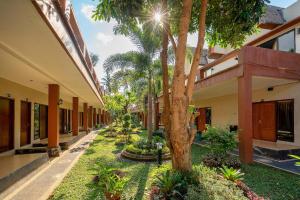 a courtyard of a building with a tree at Melati Kuta Lombok in Kuta Lombok