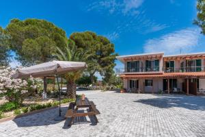 a patio with a table and an umbrella and a building at Synodinos Studios in Lixouri