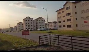 a street with buildings and a sign in the middle at Mycom Apartment in Kumasi