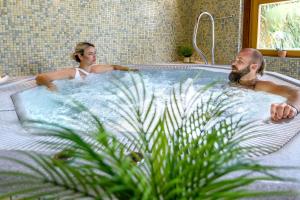 a man and woman in a hot tub at Vital Hotel Krainz mit Nebenhaus Familien Hotel in Loipersdorf bei Fürstenfeld