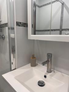 a white sink in a bathroom with a mirror at La Pinéa 40 m2 T2 climatisation, tram E et parking in Saint-Égrève +15 photos