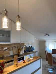 a kitchen with white cabinets and a wooden counter top at Purple Haze Apartments in Tivat