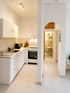 a kitchen with white cabinets and a stove top oven at Linda's Apartment in Ialysos