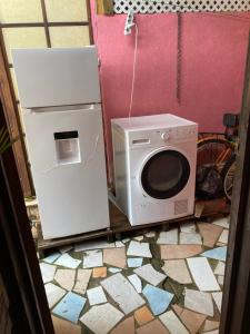 a kitchen with a microwave and a refrigerator at Maupiti Authentique in Te-Fare-Arii
