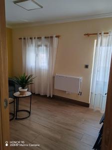 a living room with white curtains and a table at La Casita de la Suerte 3ro in Marín