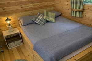 a room with a bed and pillows in a cabin at Glamping Cabins in the Heart of Snowdonia in Dolgellau +31 photos
