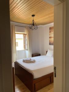 a bedroom with a bed with a wooden ceiling at Casa das Marias by Gerês Casas in Geres
