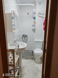 a white bathroom with a toilet and a sink at La Casita de la Suerte 3ro in Marín +10 photos