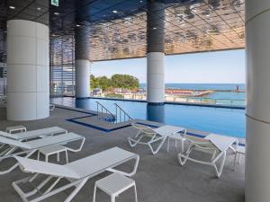 a pool with tables and chairs in a building at Plott The Gak Yangyang in Yangyang