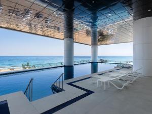 a large building with a swimming pool and the ocean at Plott The Gak Yangyang in Yangyang
