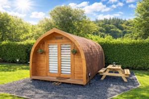 a small wooden hobbit house with a picnic table at Glamping Cabins in the Heart of Snowdonia in Dolgellau