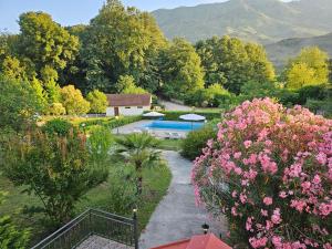 a garden with a swimming pool and pink flowers at Zeta River Retreat in Danilovgrad