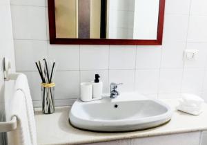 a bathroom sink with two rolls of toilet paper on it at Cosy Open Space Apartment Bari in Bari