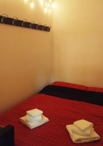 a room with two beds with red sheets and white towels at Cosy Open Space Apartment Bari in Bari