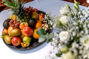a bowl of fruit on a table next to flowers at Vital Hotel Krainz mit Nebenhaus Familien Hotel in Loipersdorf bei Fürstenfeld