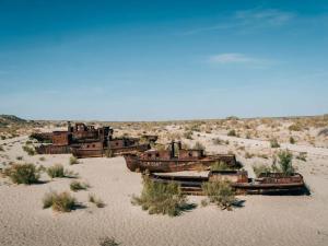 a group of old rusty ships in the desert at Yurta in Nukus
