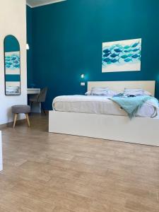 a bedroom with a bed and a blue wall at B&B La mia Isola in Castelluzzo
