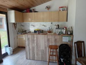 a kitchen with a wooden counter and a stool at Etno Han crvena reka in Bela Palanka