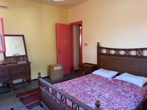 a bedroom with a bed and a mirror and a red door at Al Obayed Garden Villa in Marsa Matruh