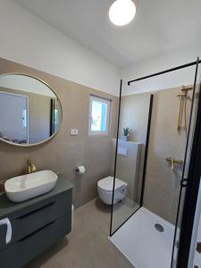 a bathroom with a sink and a toilet and a mirror at Holiday home Tcono in Tkon