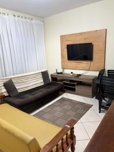 a living room with a couch and a flat screen tv at Apartamento 2 quartos em Conservatória - até 9 pessoas! in Conservatória