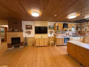 a large kitchen with wooden floors and a flat screen tv at Zejmarka in Mlynky