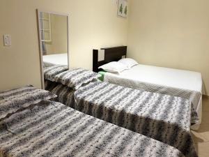 three beds in a room with a mirror at Apartamento 2 quartos em Conservatória - até 9 pessoas! in Conservatória
