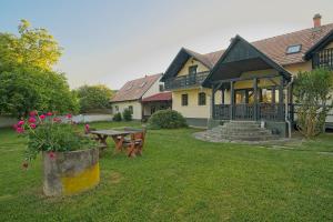 a house with a picnic table in a yard at Panzió-Kemping Bekölce in Bekölce