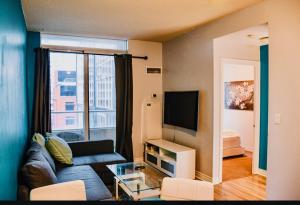 a living room with a couch and a tv at Urban Nest in Toronto