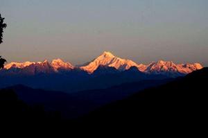a group of mountains with the sun shining on them at Baarish Home Stay in Kalimpong