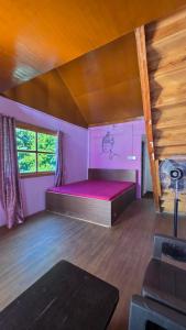 a bedroom with a bed in a room with purple walls at Baarish Home Stay in Kalimpong