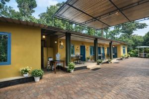 a building with yellow walls and a patio at Misty D Silver in Munnar