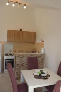 a kitchen with a white table and purple chairs at Aurora Residence in Nalježići