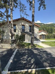 a stone house with trees in front of it at Appartement SUOMI in Saint-Sorlin-en-Bugey