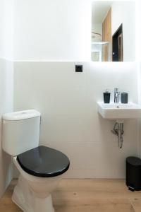a white bathroom with a toilet and a sink at Apartmán Mafin in Jáchymov