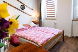 a bedroom with a bed and a table and flowers at Apartmán Mafin in Jáchymov