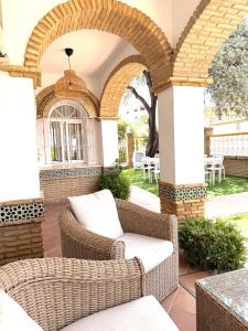 an outdoor patio with wicker chairs and tables at Hotel Victoria Matalascañas in Matalascañas