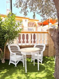 a white table and chairs in front of a house at Hotel Victoria Matalascañas in Matalascañas