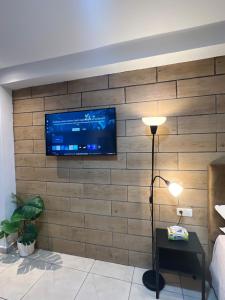 a living room with a tv on a brick wall at Modern Studio in Kenitra